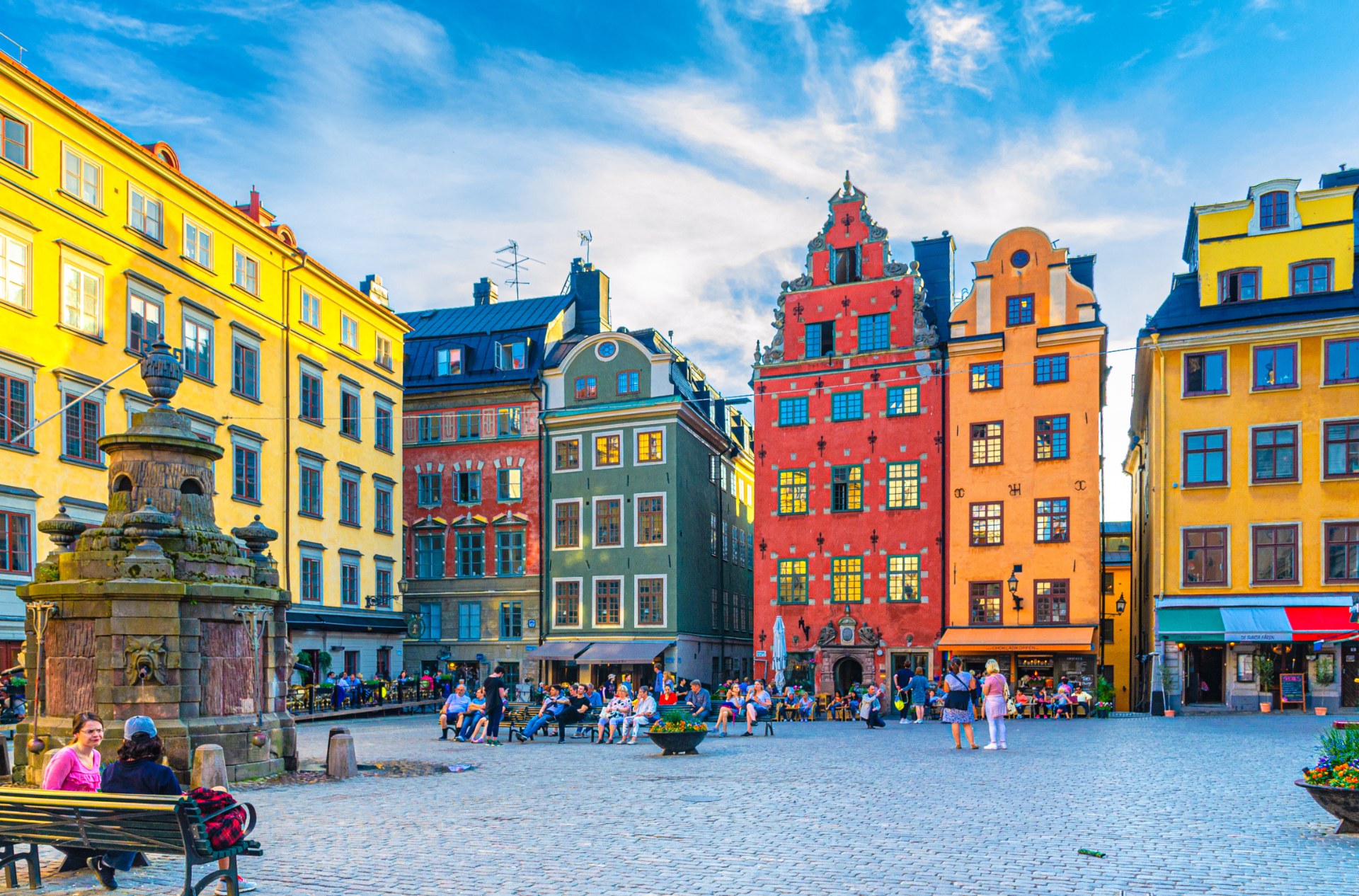 Turisti a okoloidúci na námestí Stortorget v Štokholme medzi farebnými meštianskymi domami